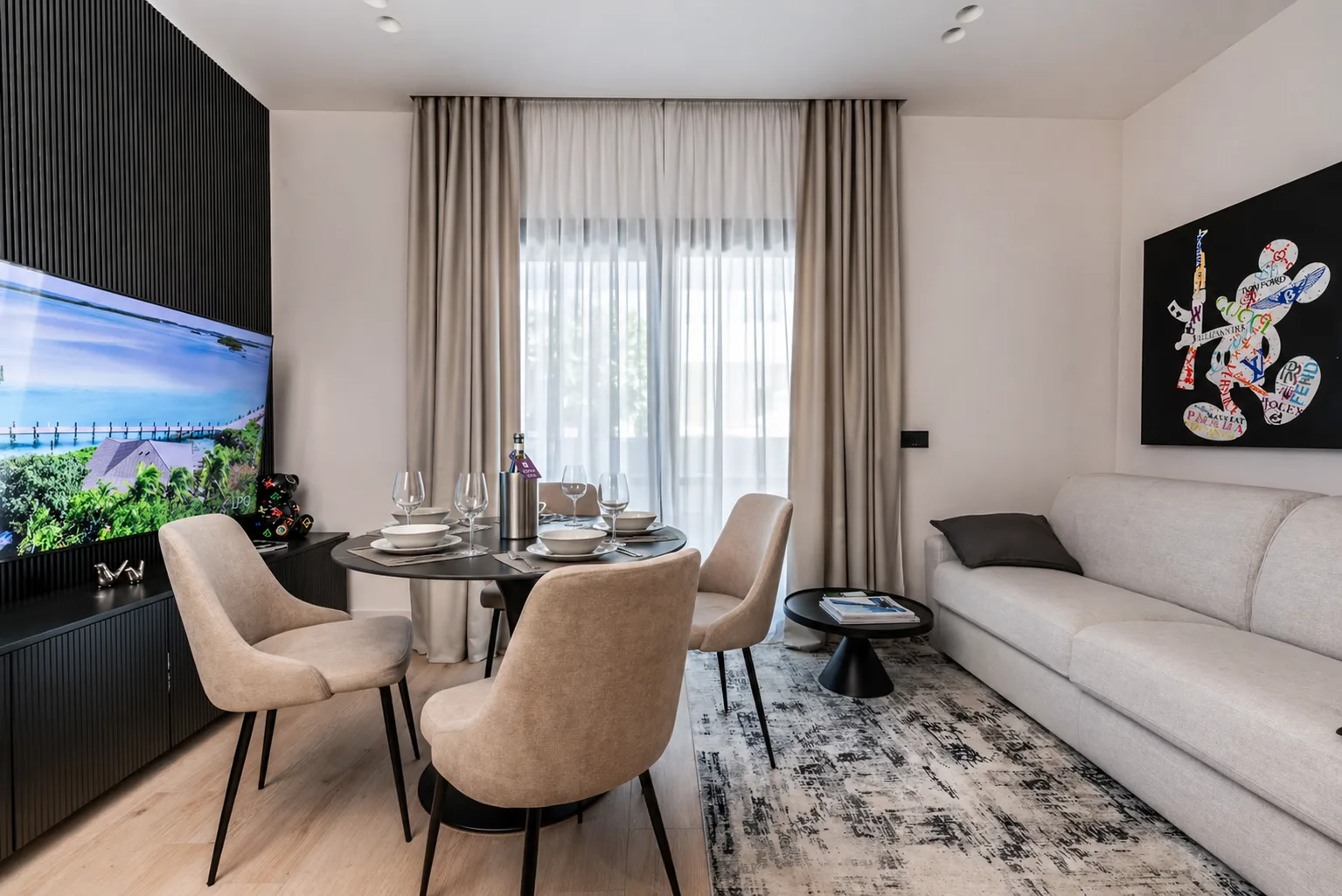 AZULIS Apartments: living and dining room with round table, sofa and colourful portrait artwork, Via Pisano 16, Olbia